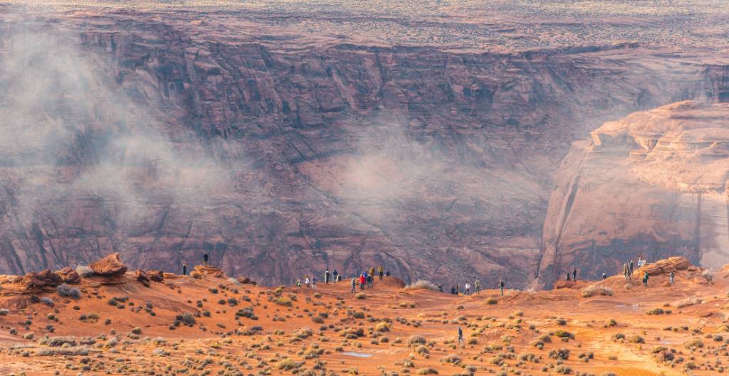 visitors standing at the overlook of horseshoe bend