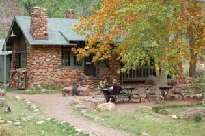 people sitting at a picnic table outside phantom ranch lodge