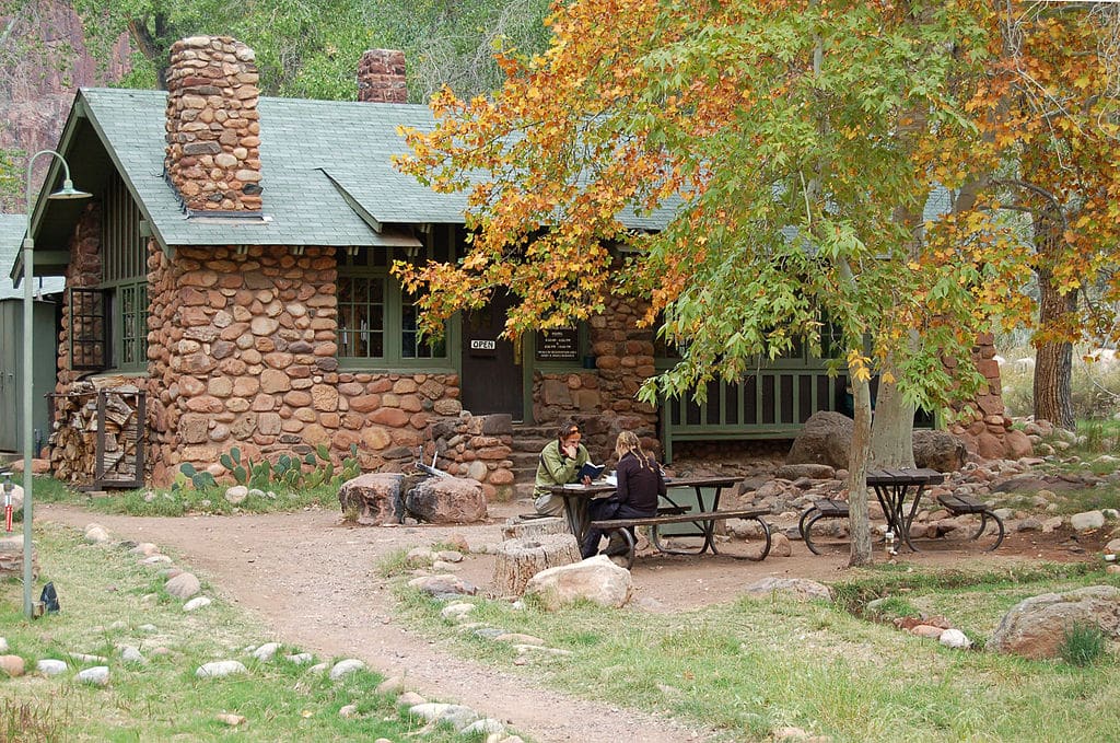 people sitting at a picnic table outside phantom ranch lodge