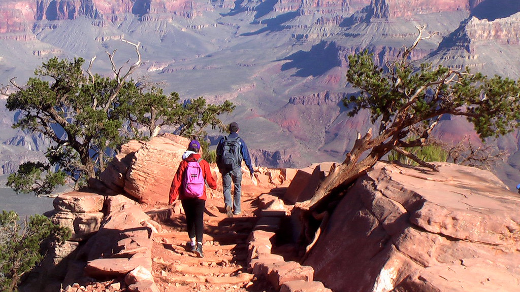 11two people wearing backpacks hiking in the grand canyon