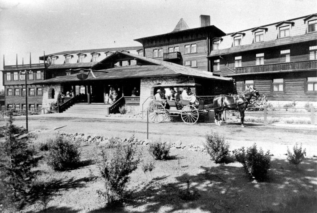 historical black and white photo of el tovar hotel with horse and carriage out front