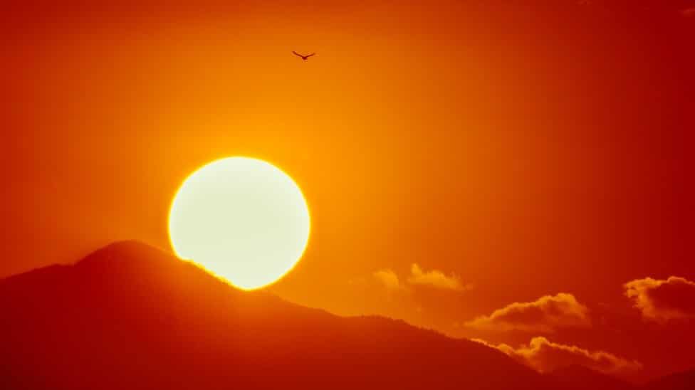 large yellow sun in glowing red sky