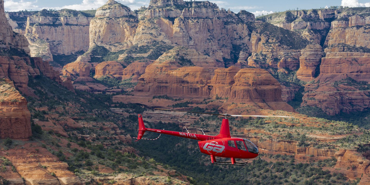 11red helicopter flying through grand canyon