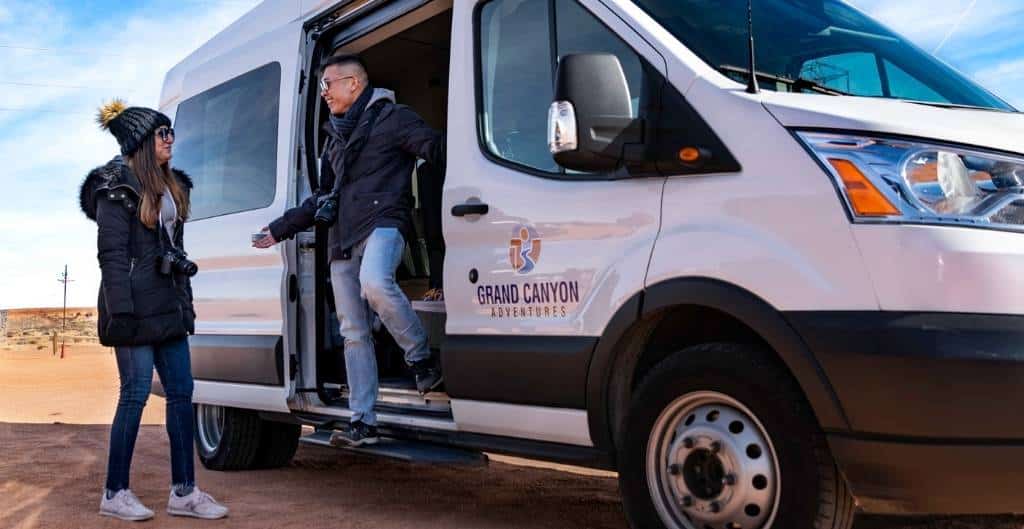 two people stepping out of grand canyon adventures van