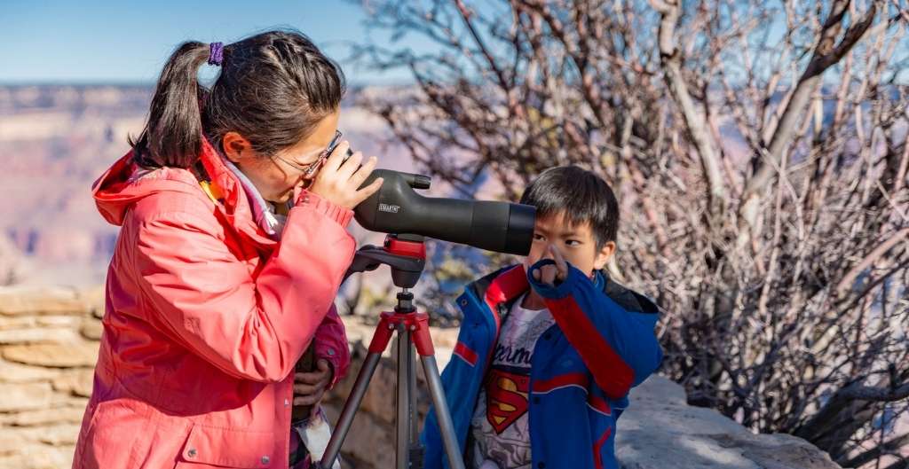 woman and child looking through spotting scope