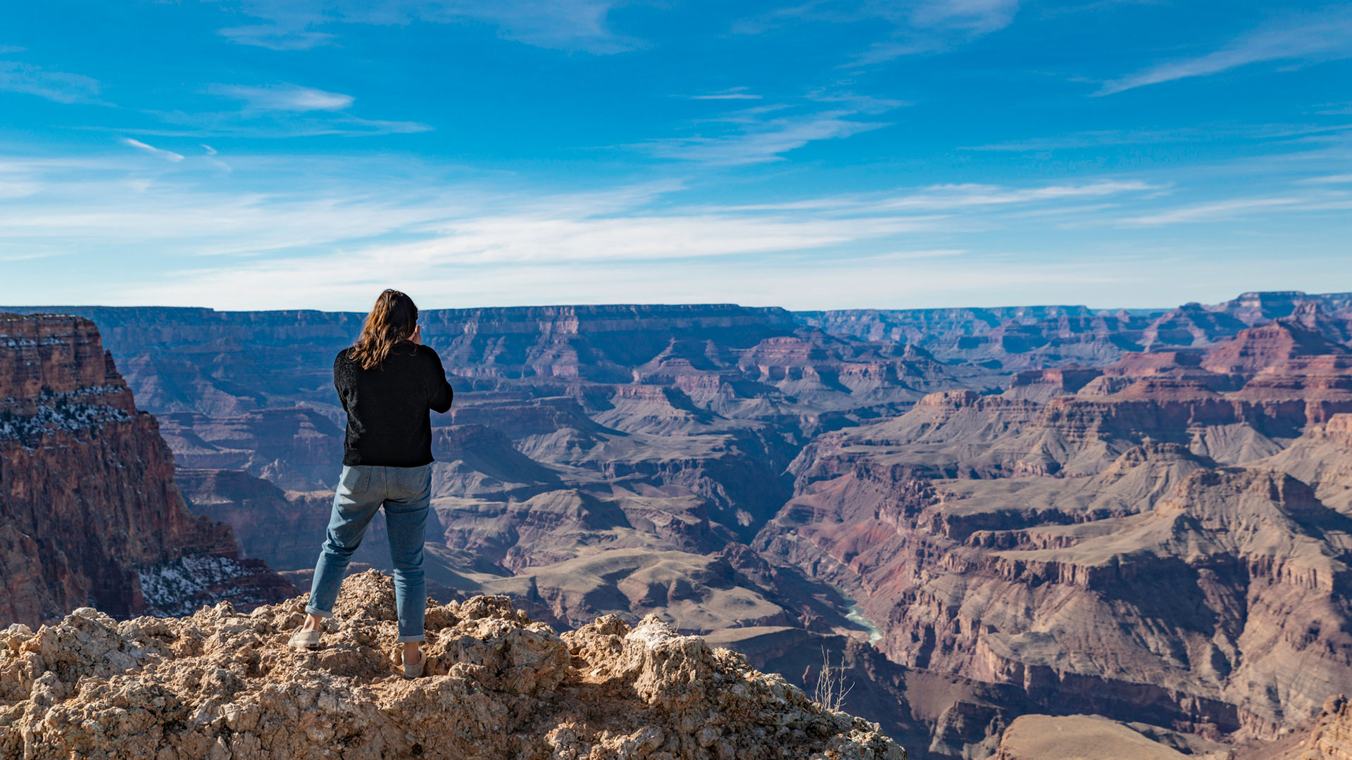 woman taking a picture of the grand canyon