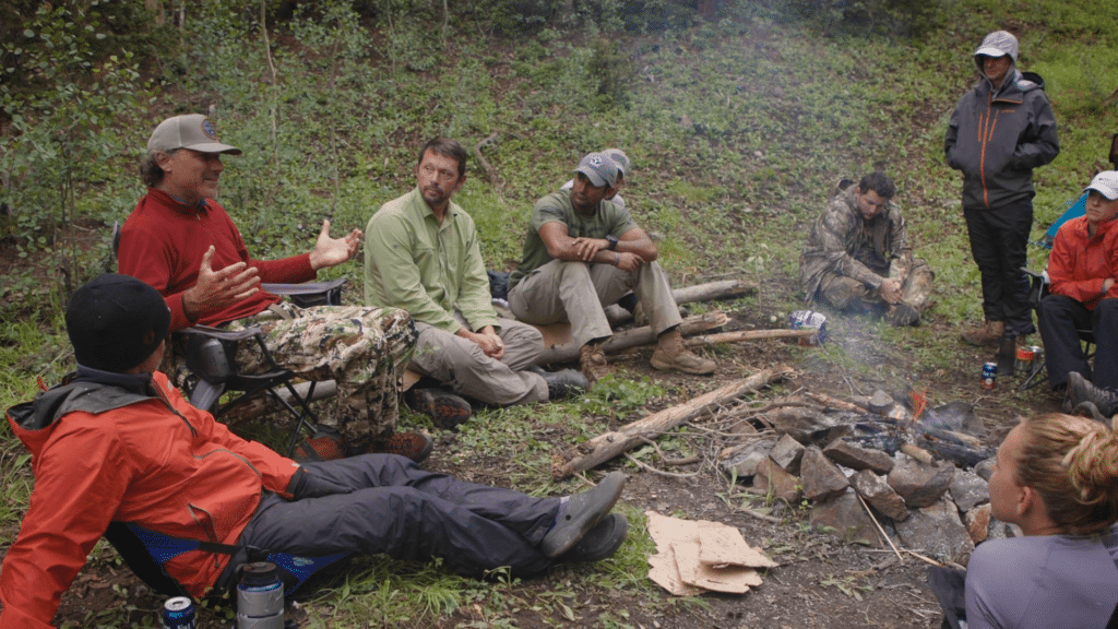 group of people around a campfire on a group hiking trip