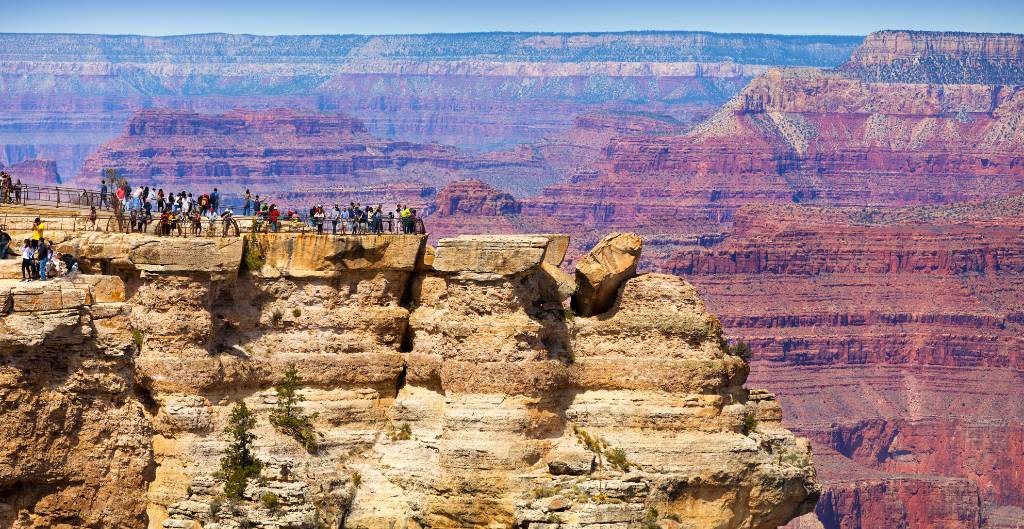 group of visitors at a viewpoint looking into the grand canyon