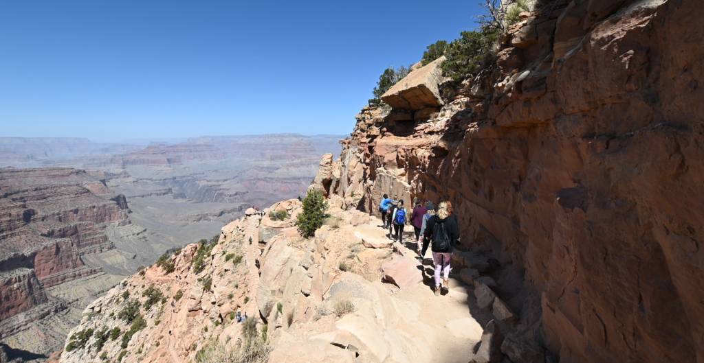 group of people on a hiking trail at the grand canyon