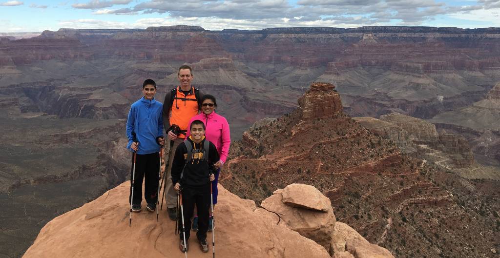 parents and two kids posing for a photo at the grand canyon