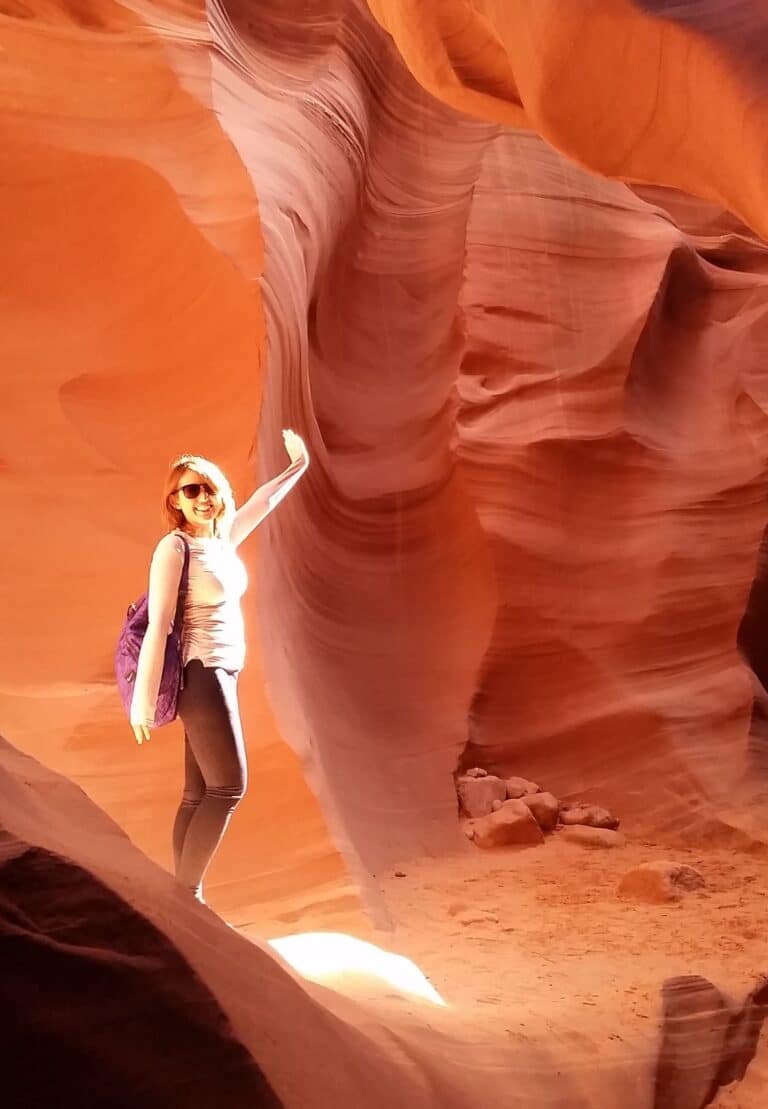 A woman poses in the light beaming through antelope canyon