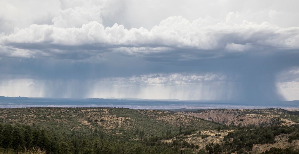 rain falling from clouds over an arizona valley