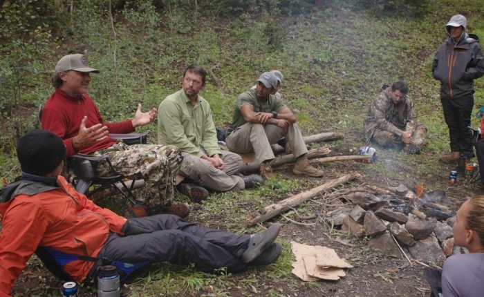 team-building group sitting around a campfire