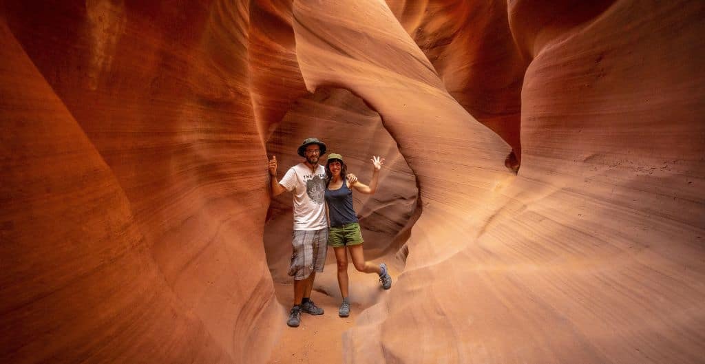 Two people smile from inside the lower antelope canyon